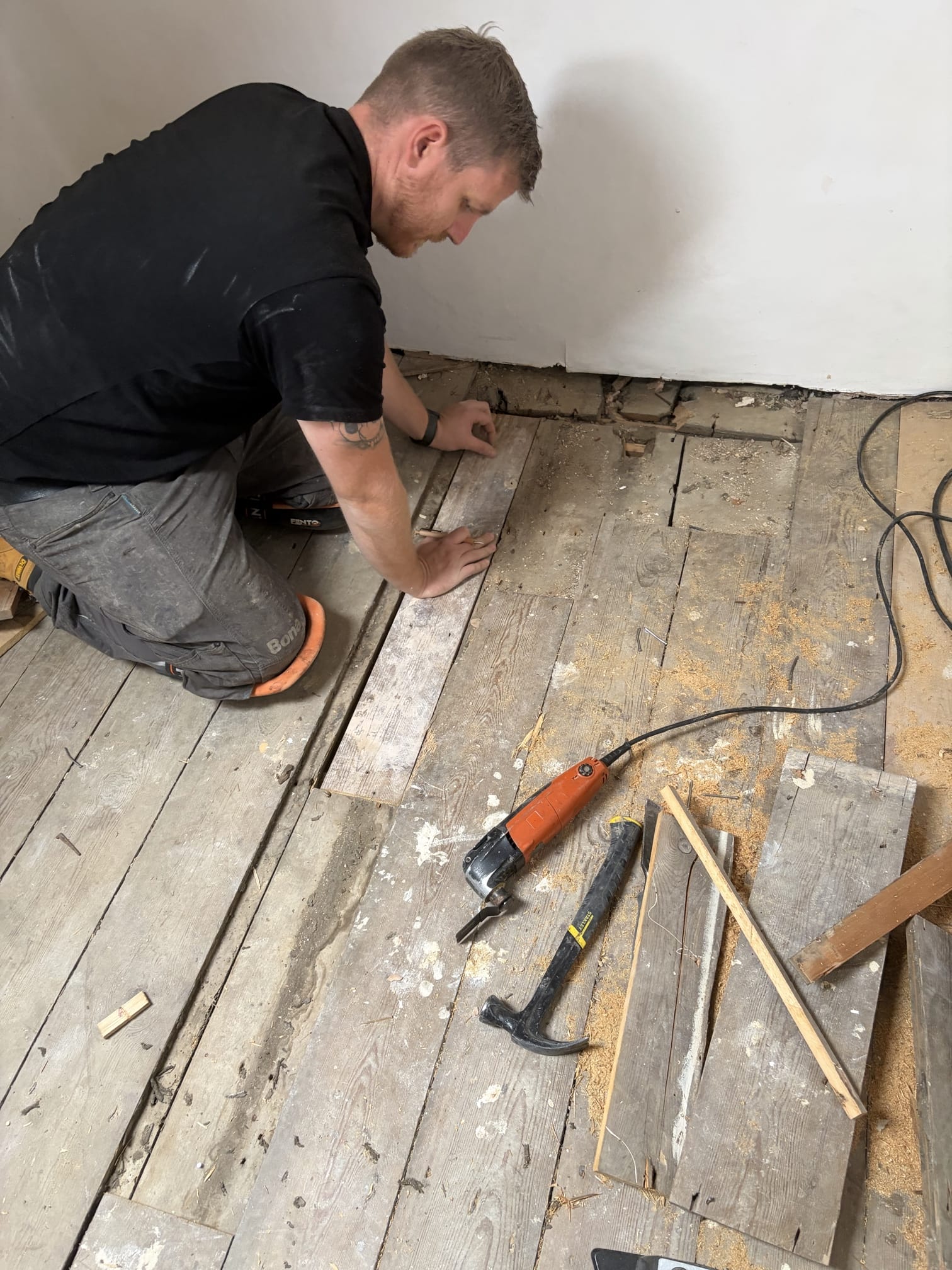 Robby our Wood Floor Technician repairing wood floors before sanding and finishing